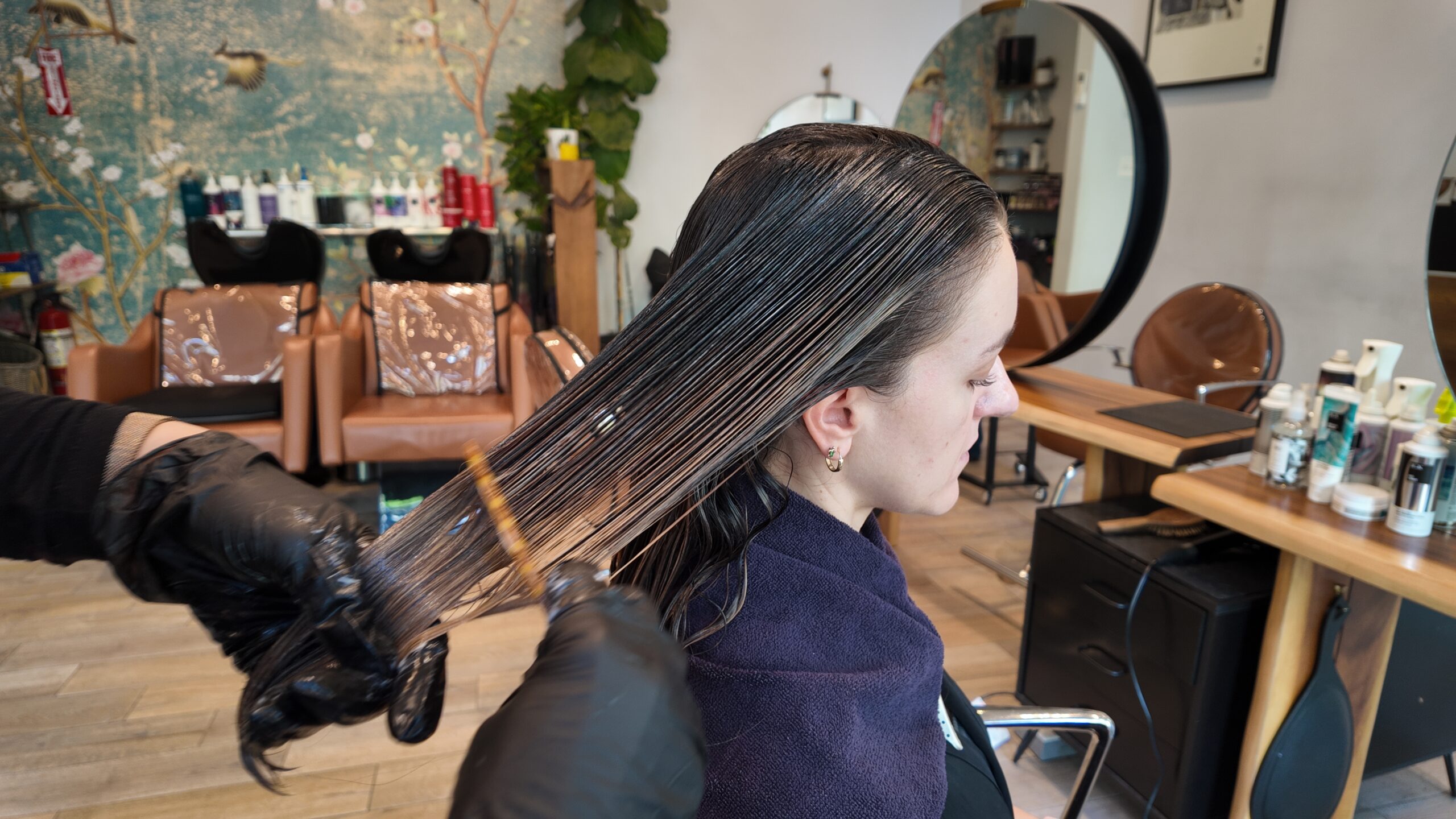 Person with wet hair getting a hair treatment at a salon.