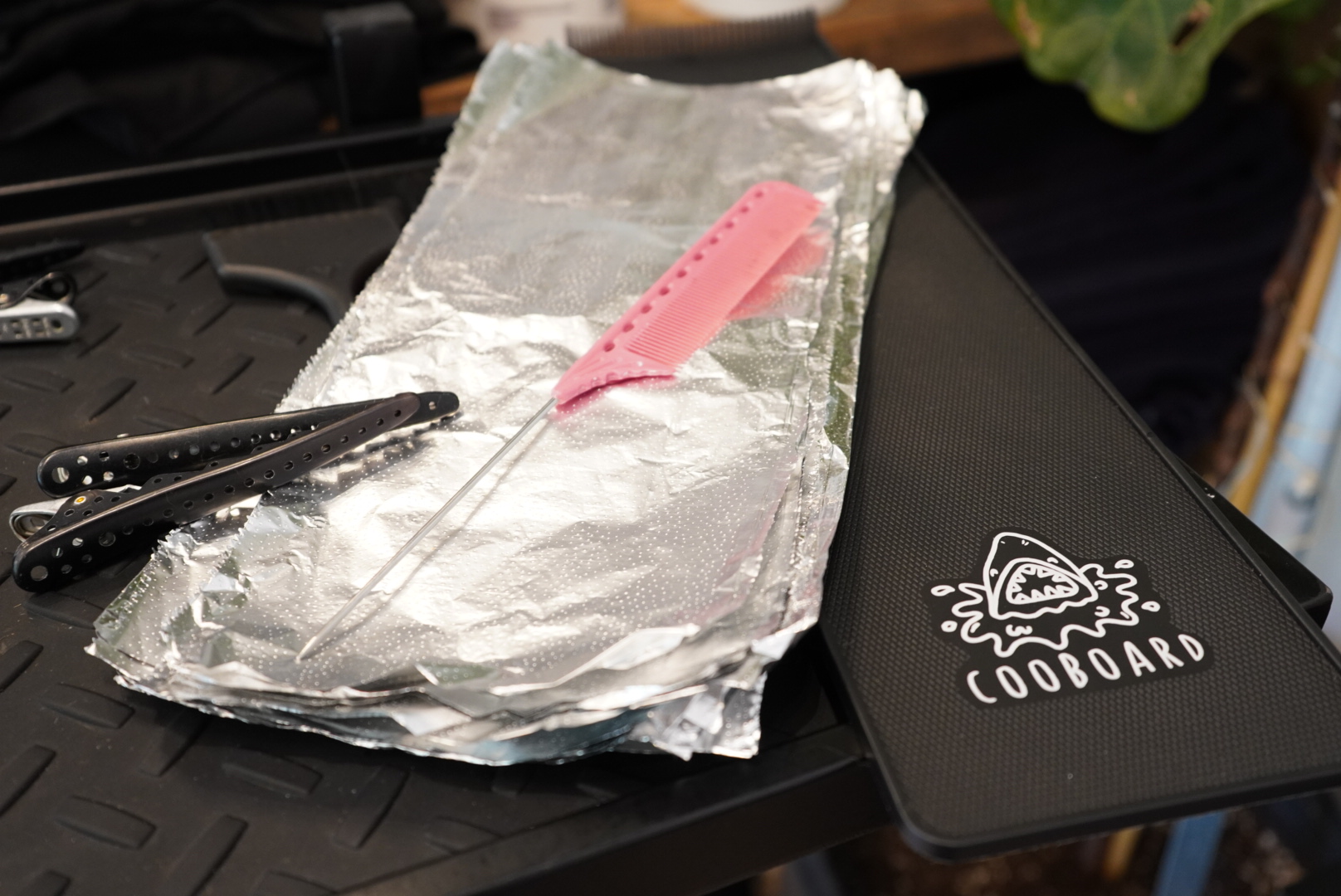 Tattoo equipment including needle, foil, and clipcord cover on a work surface.