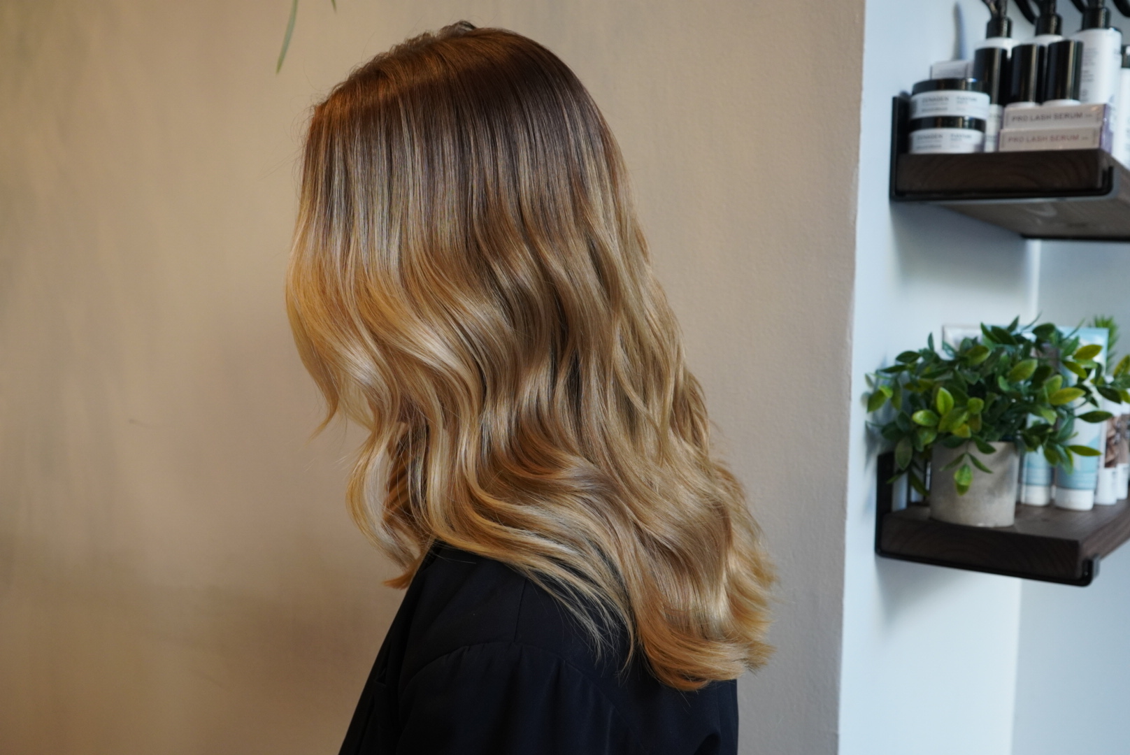 Woman with wavy, blonde hair in a salon setting.