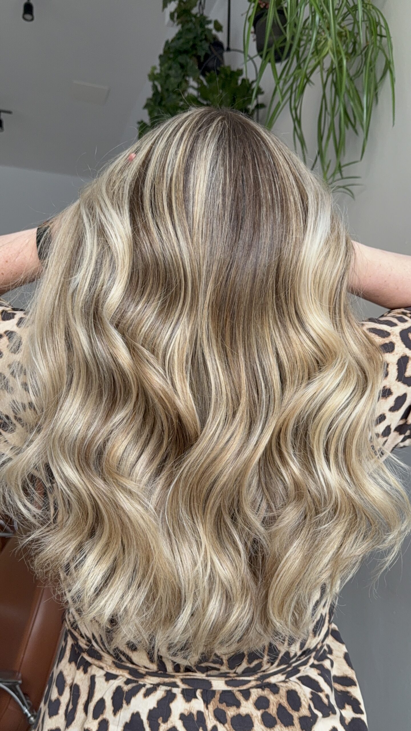 Woman with wavy blonde hair in a leopard print top.